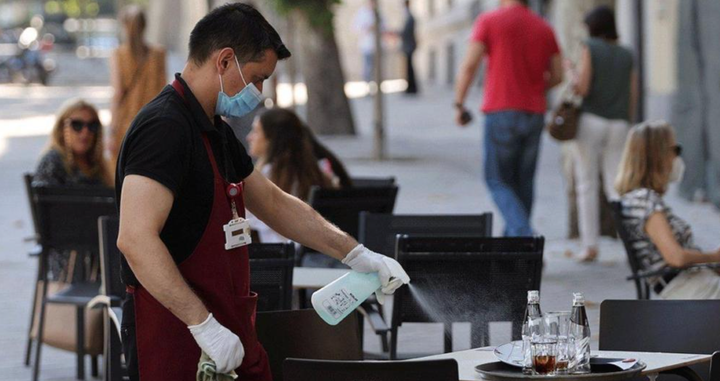 Un camarero limpia una mesa