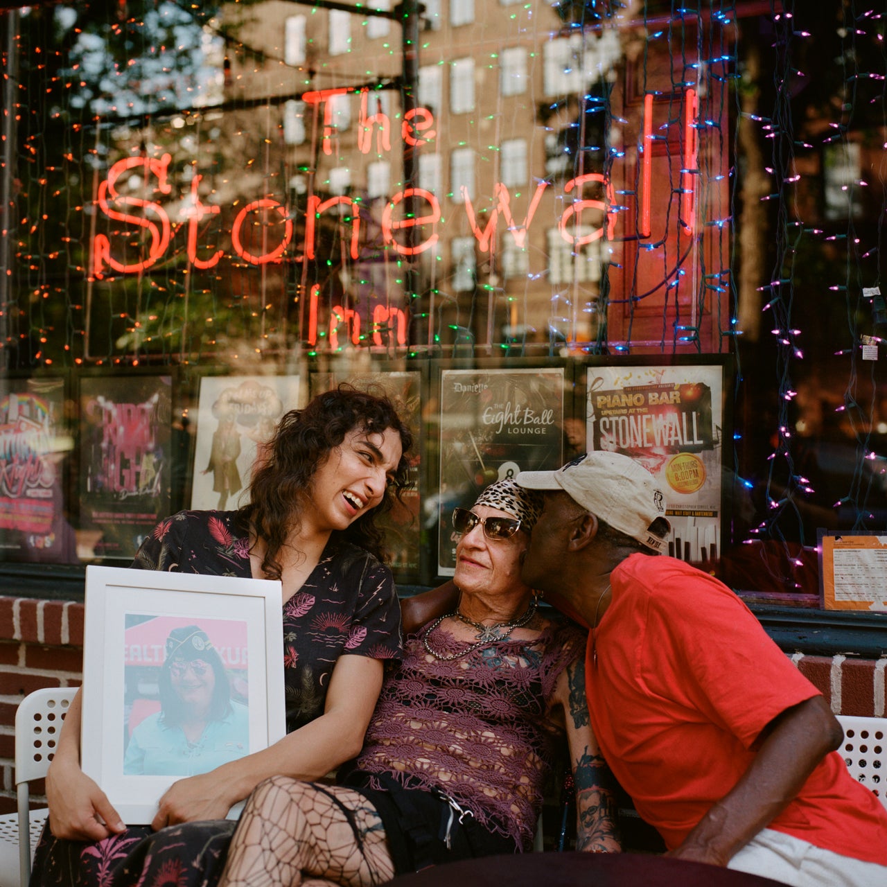 Already give their flowers to these elder heroes 6 Lara, Reneé and Albert with a photo of Janice in front of The Stonewall Inn.