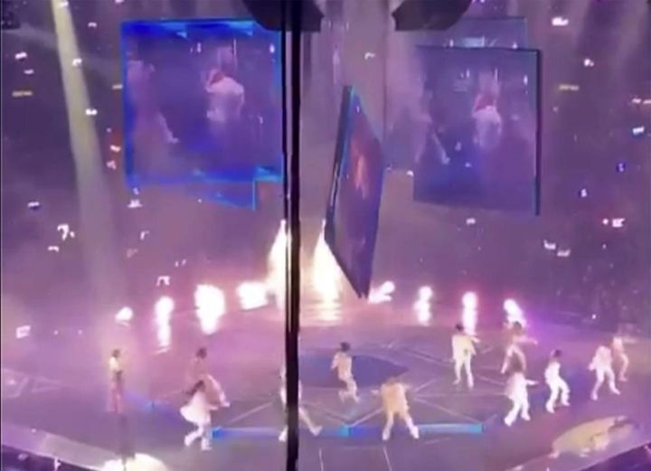 A video screen suspended above the stage falls onto the stage where dancers perform at a concert of Cantopop boy band Mirror in Hong Kong on July 28.