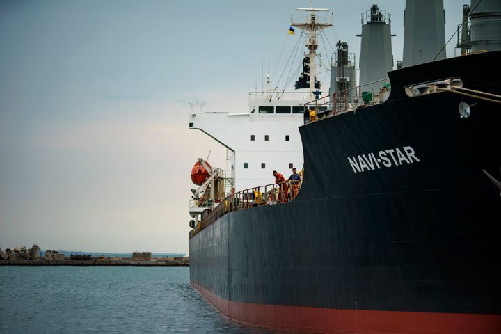 Εργαζόμενοι στέκονται στο κατάστρωμα του πλοίου Navi-Star που κάθεται γεμάτο σιτηρά από τότε που ξεκίνησε η εισβολή της Ρωσίας στην Ουκρανία πριν από πέντε μήνες καθώς περιμένει να αποπλεύσει από το λιμάνι της Οδησσού της Ουκρανίας, Παρασκευή 29 Ιουλίου 2022. (AP Photo/David Goldman)