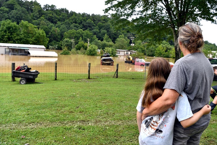 Bonnie Combs, right, hugs her 10-year-old granddaughter Adelynn Bowling as her property remains flooded by the North Fork of the Kentucky River in the town of Jackson on July 28.