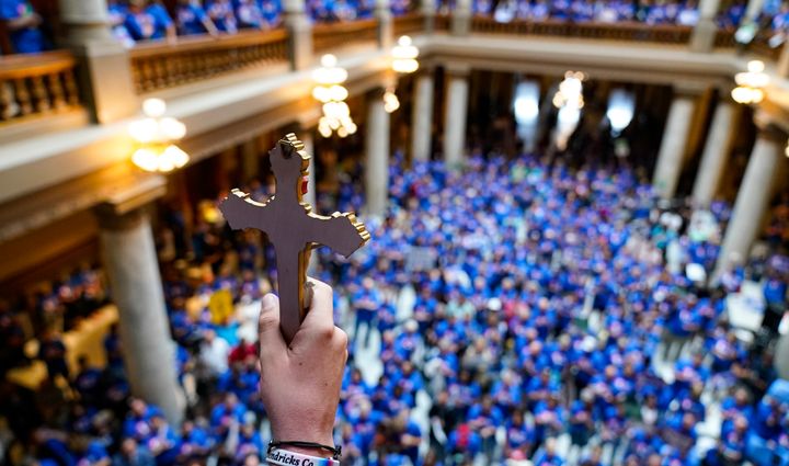 An anti-abortion advocate holds a crucifix up as anti-abortion supporters rally at the Indiana State Capitol ahead of the legislature debating a proposal to ban nearly all abortions in the state.