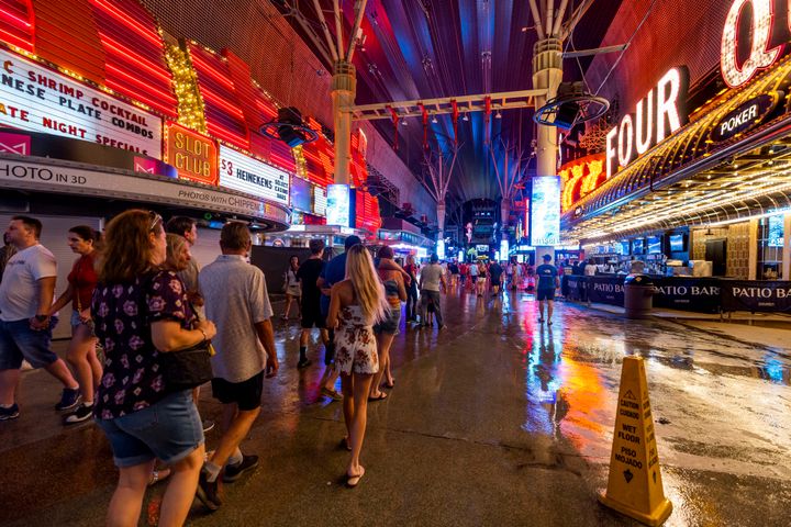 People navigate the rainy walkways as some power is out at the Fremont Street Experience as a powerful storm moves through the area on Thursday, July 28, 2022, in Las Vegas.