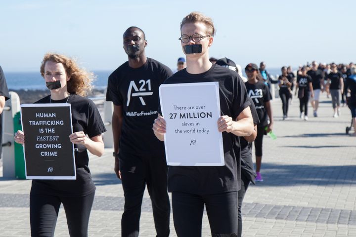 Άνθρωποι με μαύρη ταινία στο στόμα τους περπατούν κατά μήκος της ακτής Sea Point καθώς παρευρίσκονται σε μια διαμαρτυρία κατά της εμπορίας ανθρώπων στο Κέιπ Τάουν της Νότιας Αφρικής στις 17 Οκτωβρίου 2015.