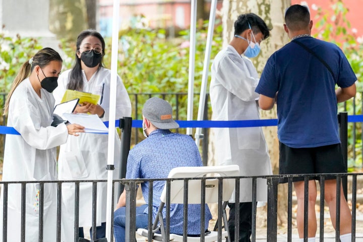 New York City Department of Health and Mental Hygiene workers help people register for the monkeypox vaccine at one of the city's vaccination sites on Tuesday.