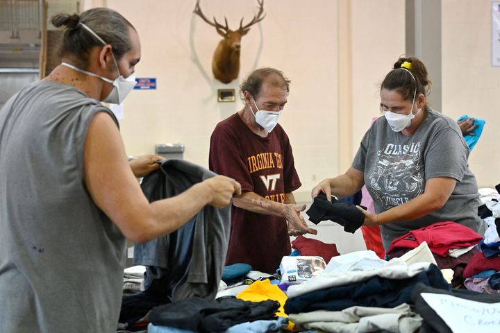 Evacuees of the flooding in eastern Kentucky gather clothing at the Knott County Sportsplex in Leburn, Ky., Friday, July 29, 2022. The sportsplex is being used as an emergency shelter, providing food, clothing, and a place to stay for those displaced by the flooding. (AP Photo/Timothy D. Easley)