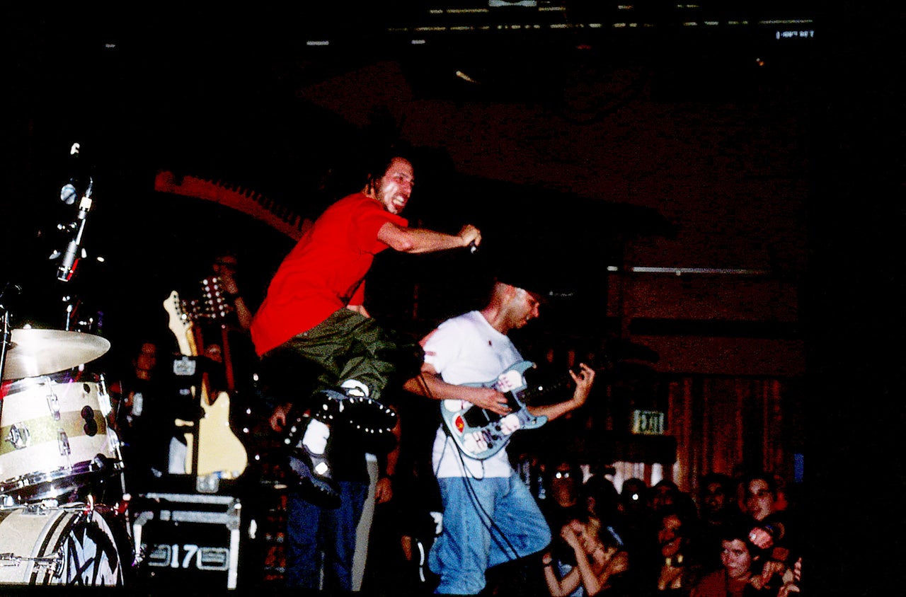 Vocalist Zack de la Rocha jumps high from the stage as he performs with guitarist Tom Morello, bassist Tim Commerford, and drummer Brad Wilk in Rage Against the Machine on Jan. 23, 1999, at The Troubadour in West Hollywood.