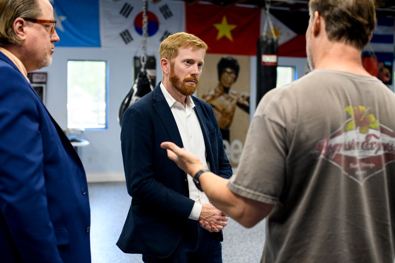 Rep. Peter Meijer (R-Mich.), left, speaks with Tim Faasse, right, at Blues Gym in Grand Rapids, Michigan, on July 25. Meijer answered a question about supply chains.