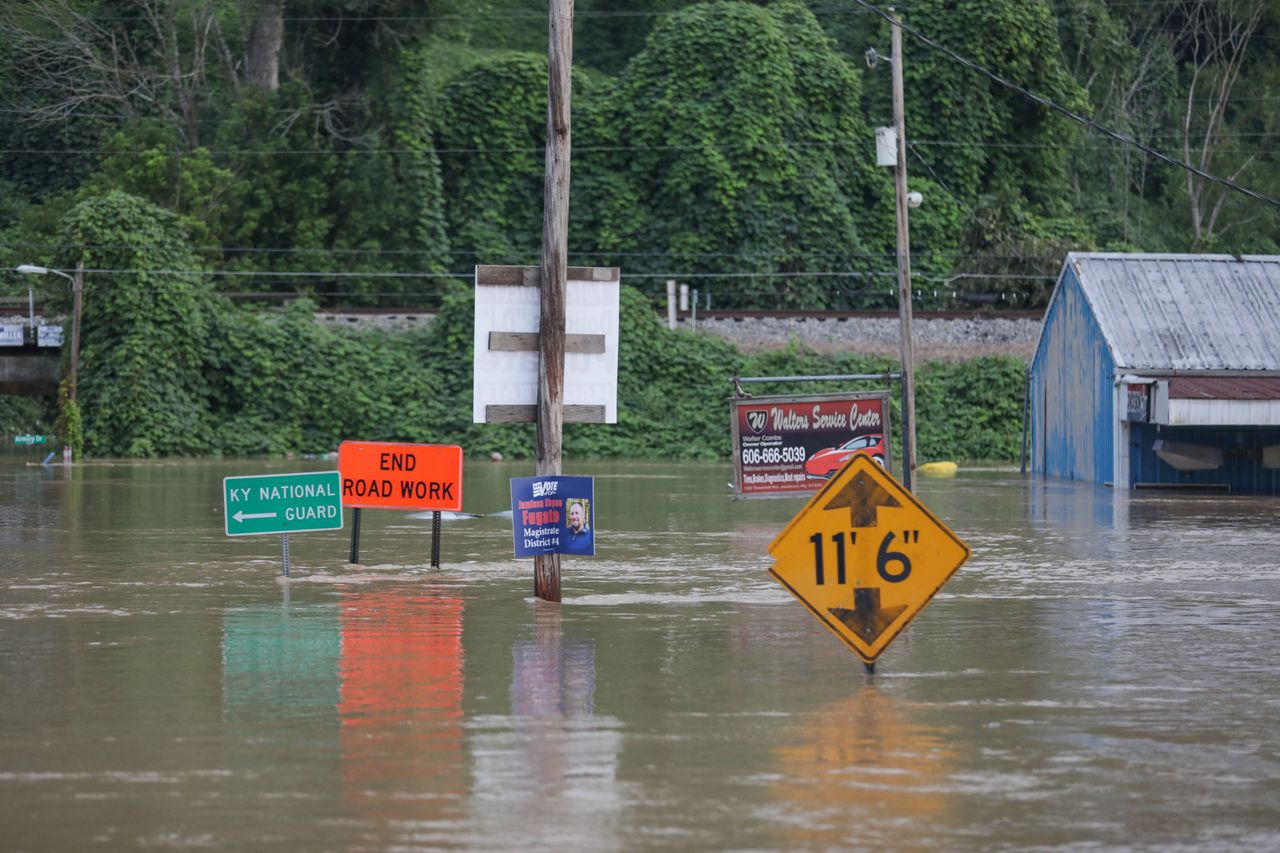 Road signs are barely visible on a road covered by floodwaters from the North Fork of the Kentucky River in Jackson, Kentucky, on July 28.