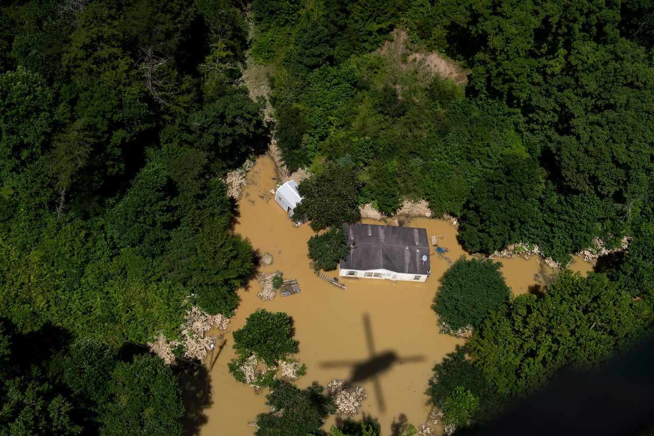 In this aerial view, floodwater surrounds a house as the Kentucky National Guard flies a recon and rescue mission in Breathitt County near Jackson, Kentucky, on July 30.