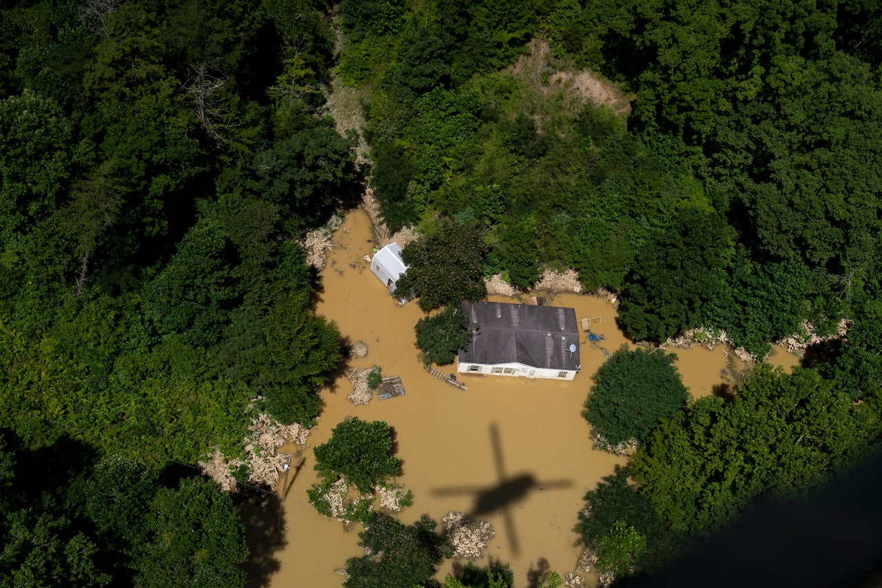 In this aerial view, floodwater surrounds a house as the Kentucky National Guard flies a recon and rescue mission in Breathitt County near Jackson, Kentucky, on July 30.