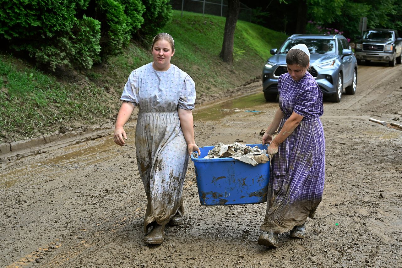 Volunteers from the local mennonite community carry tubfulls of debris from flood soaked houses for disposal at Ogden Hollar in Hindman, Kentucky, on July 30.