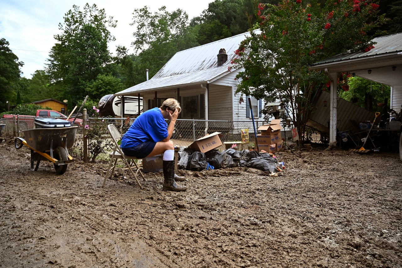 Teresa Reynolds sits exhausted as members of her community clean the debris from their flood ravaged homes at Ogden Hollar in Hindman, Kentucky, on July 30.