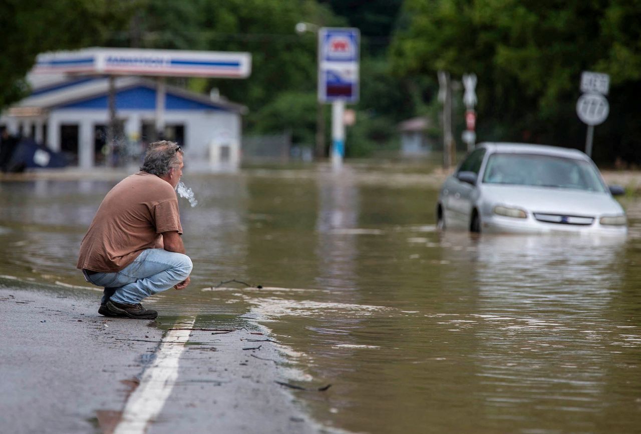 Van Jackson checks on his dog, Jack, who was stranded at a church by flood waters along Right Beaver Creek, following a day of heavy rain in in Garrett, Kentucky, on July 28. Jackson owns an auto parts store in town and said he doesn't have flood insurance to cover his loss.