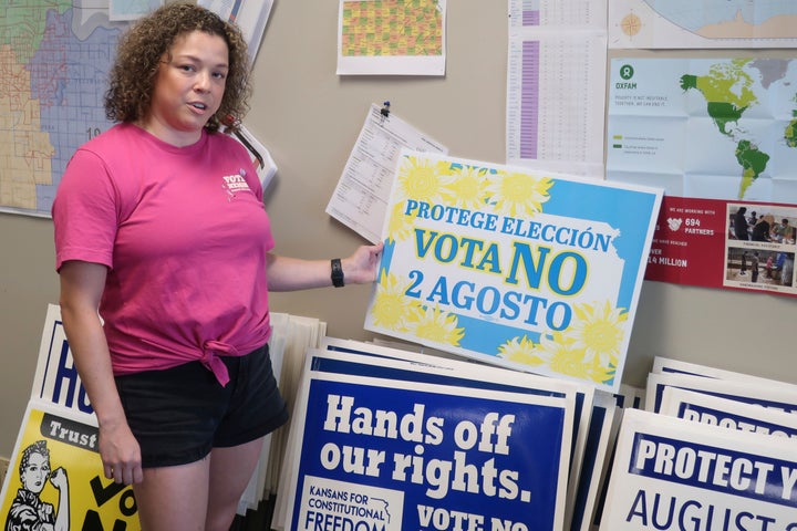 Le Kansas organisera mardi le premier test du pays sur les sentiments des électeurs concernant la récente décision de la Cour suprême annulant Roe v. Wade.  Jessica Porter, présidente des communications du comté de Shawnee, Kansas, Parti démocrate, discute d'un panneau en espagnol exhortant les électeurs à s'opposer à l'amendement proposé.