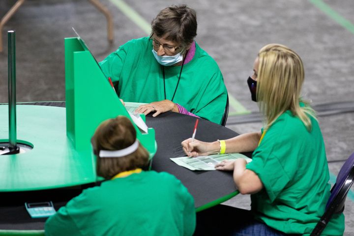 Contractors working for Cyber Ninjas, who was hired by the Arizona State Senate, examine and recount ballots from the 2020 general election at Veterans Memorial Coliseum on May 8, 2021, in Phoenix, Arizona. 
