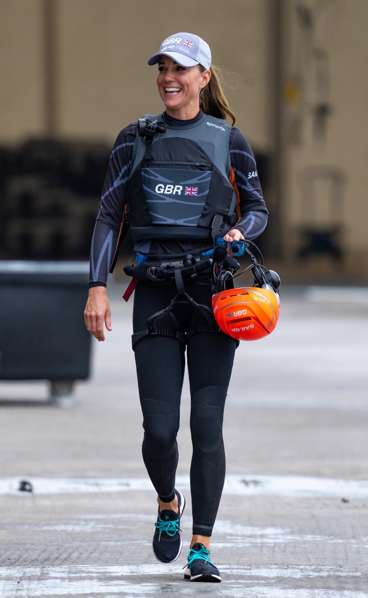 Kate walks through the Technical Base in a Great Britain SailGP Team wetsuit. 