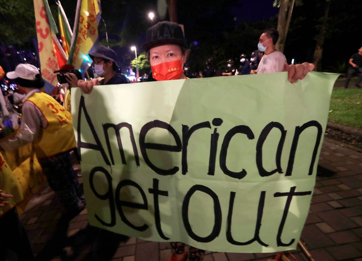 A protester holds a banner during a protest against the visit of United States House Speaker Nancy Pelosi, outside a hotel in Taipei, Taiwan, Tuesday, Aug 2, 2022.