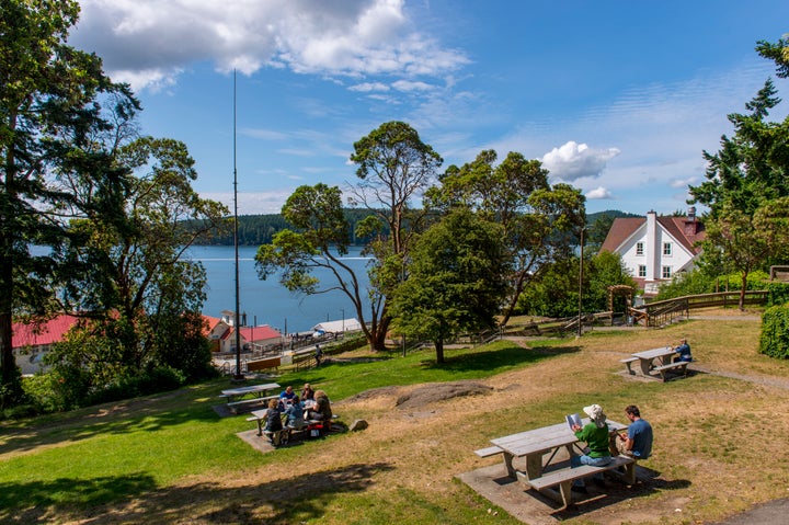 People sitting in a park above the ferry dock in Orcas Village on Orcas Island in the San Juan Islands in Washington. The archipelago is the heart of the state's 40th legislative district.