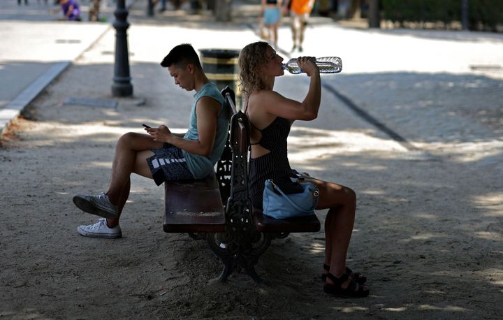 Una mujer bebiendo agua en un parque madrileño, en plena de ola de calor.