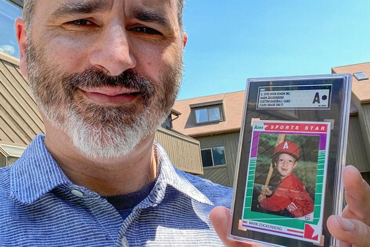 This photo provided on Wednesday, Aug. 3, 2022, shows Allie Tarantino holding a baseball card featuring a very young Mark Zuckerberg grinning in a red jersey and gripping a bat. (Shira Tarantino via AP)