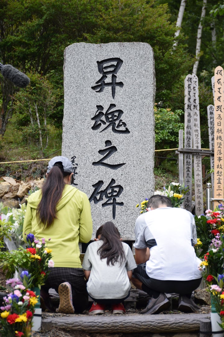 日航機墜落事故の現場「御巣鷹の尾根」に建つ「昇魂之碑」の前で手を合わせる遺族＝2021年8月12日、群馬県上野村