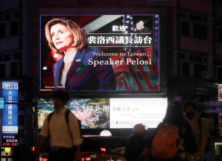 People walk past a billboard welcoming U.S. House Speaker Nancy Pelosi, in Taipei, Taiwan, on Aug 2, 2022. 