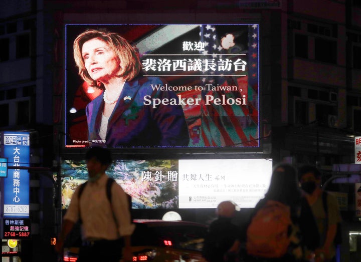 People walk past a billboard welcoming US House Speaker Nancy Pelosi, in Taipei, Taiwan, on August 2, 2022. 