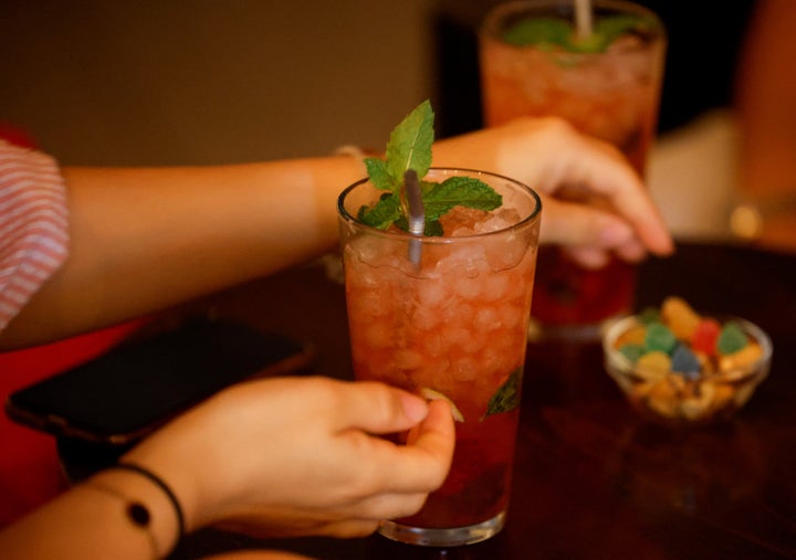 A woman sits at a bar to drink a mojito in Madrid, Spain, August 4, 2022. REUTERS/Juan Medina