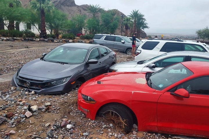 In this photo provided by the National Park Service, cars are stuck in mud and debris from flash flooding at The Inn at Death Valley in Death Valley National Park, Calif., Friday, Aug. 5, 2022. Heavy rainfall triggered flash flooding that closed several roads in Death Valley National Park on Friday near the California-Nevada line.