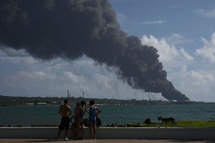 People look at the black smoke above the oil storage facility site in Matanzas, Cuba on Saturday.