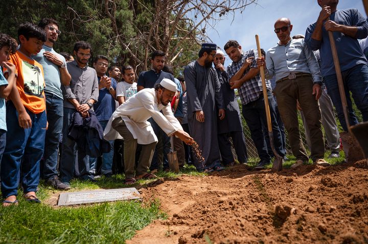 People pour dirt over the grave of Muhammad Afzaal Hussain, 27, in Albuquerque during a funeral Friday for him and Aftab Hussein, 41. Both Muslims were shot and killed near their homes just six days apart.