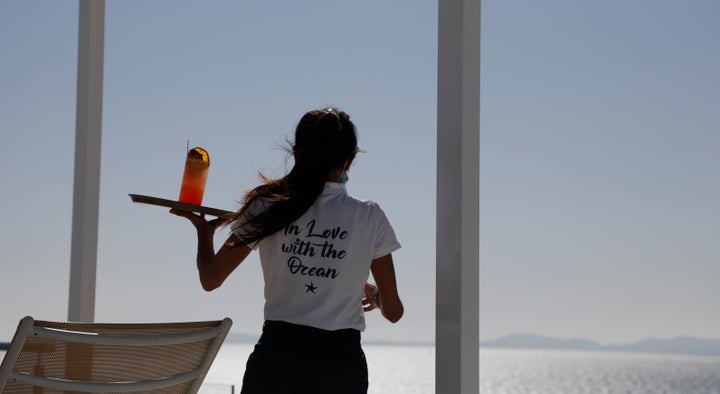 PRODUCTION - 11 May 2022, Spain, Palma: A waitress serves a drink in the rooftop swimming pool of the Iberostar Bahia de Palma hotel on Arenal beach in Mallorca. The tourism industry on the vacation island of Mallorca, which is popular with Germans, is looking to the future with renewed optimism this year. (to dpa "Hotels on Mallorca hope for good first season without Corona rules") Photo: Clara Margais/dpa (Photo by Clara Margais/picture alliance via Getty Images)