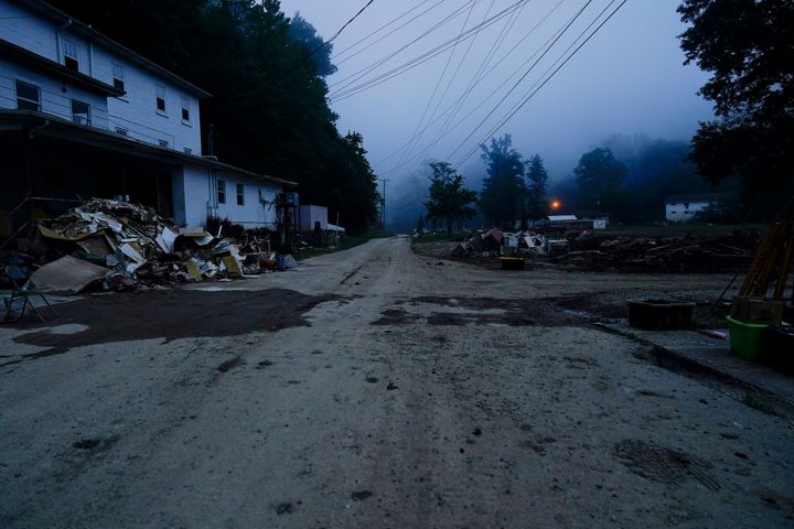 Piles of debris and a mud cover road are seen after massive flooding on Friday, Aug. 5, 2022, in Lost Creek, Ky.