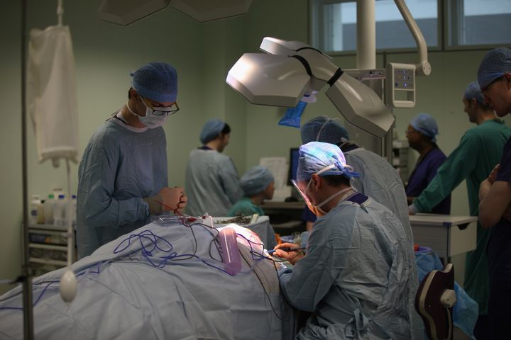 A surgeon performs a neck and throat operation.