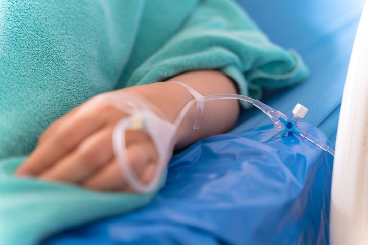 hand of the patient is on drip receiving a saline solution on bed VIP room at hospital. Medical Concept.