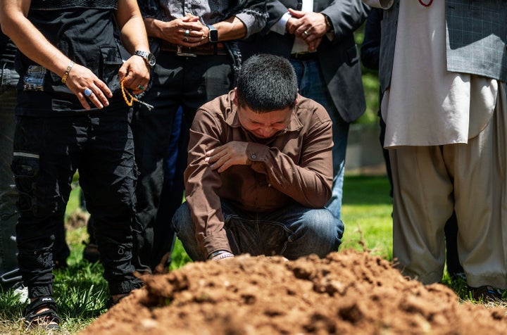 Altaf Hussain cries over the grave of his brother Aftab Hussein at Fairview Memorial Park in Albuquerque, N.M., on Friday, Aug. 5, 2022. A funeral service was held for Aftab Hussein, 41, and Muhammad Afzaal Hussain, 27, at the Islamic Center of New Mexico on Friday. Both Muslim men were shot and killed near their homes only six days apart. (Chancey Bush/The Albuquerque Journal via AP)