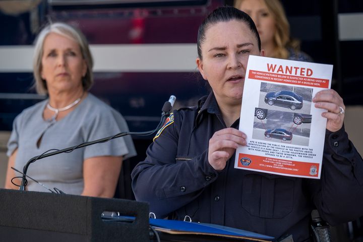 Albuquerque Police Deputy Chief of Investigations Cecily Barker holds a flyer with photos of a car wanted in connection with Muslim men murdered as Governor Michelle Lujan Grisham looks on in Albuquerque, New Mexico, Sunday, Aug. 7, 2022. (Adolphe Pierre-Louis/Albuquerque Journal via AP)
