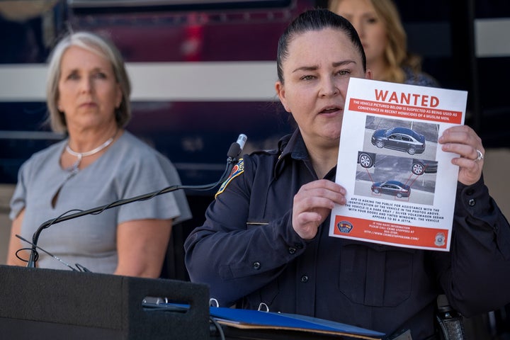 Albuquerque Police Deputy Chief of Investigations Cecily Barker holds a flyer with photos of a car wanted in connection with Muslim men murdered as Governor Michelle Lujan Grisham looks on in Albuquerque, New Mexico, Sunday, Aug. 7, 2022. (Adolphe Pierre-Louis/Albuquerque Journal via AP)