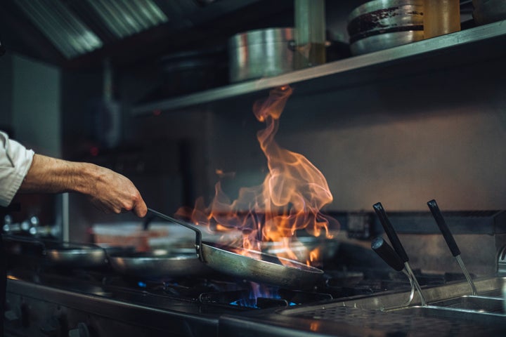 Un cocinero entre fogones.