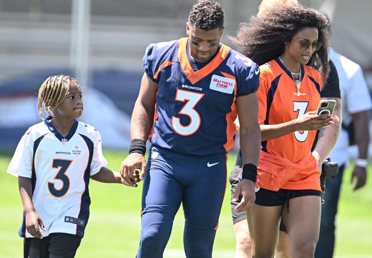 ENGLEWOOD , CO - JULY 27: Denver Broncos quarterback Russell Wilson (3) walks off the field with his son, Future, and wife, Ciara, during training camp at UCHealth Training Center.