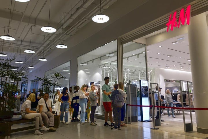 People line up to enter an H&M shop and buy items on sale in the Aviapark shopping mall in Moscow, Russia on Aug. 9.