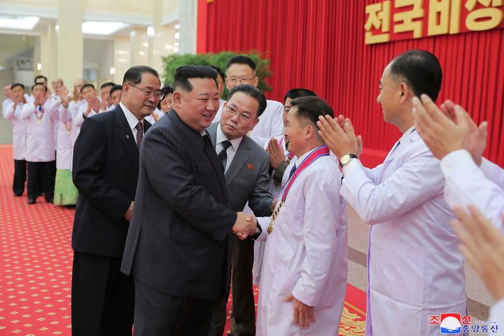 In this photo provided by the North Korean government, North Korean leader Kim Jong Un shakes hands with a health official in Pyongyang, North Korea, on Aug. 10, 2022. Kim has declared victory over COVID-19 and ordered an easing of preventive measures. Independent journalists were not given access to cover the event depicted in this image distributed by the North Korean government.