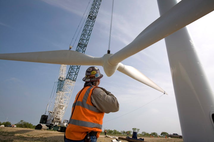 A 300-foot crane slowly lifts a rotor onto a tower on the Lone Star Wind Farm near Abilene, Texas.