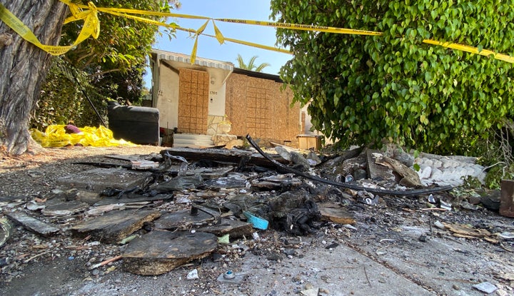 Charred debris and caution tape are seen at the site where Anne Heche crashed her car.