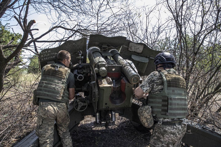 Dos militares ucranianos ponen a punto un cañón de artillería en Jersón, en julio.