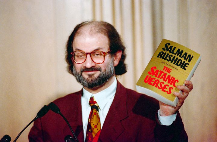 Salman Rushdie holds up a copy of his book The Satanic Verses at Freedom Forum in Arlington, Virginia in March 1992.