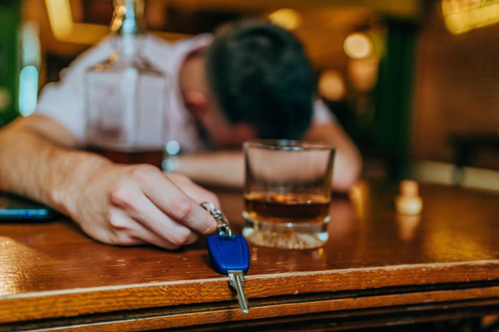 Drunk man sleeping on the table at pub with car keys in hand