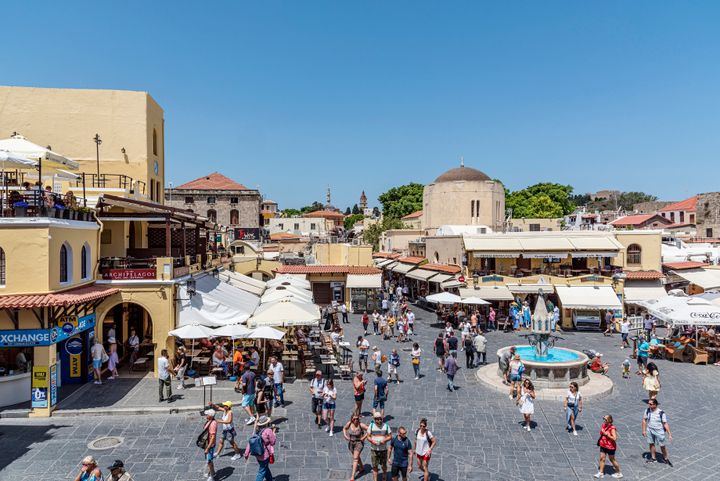 Rhodes Island, Greece - 27 May, 2022: Tourists on the historic Hippocrates Square, in the Old Town center of the island of Rhodes, Greece. Hippocrates Fountain.