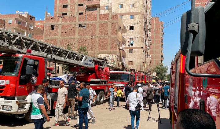 Emergency personnel work at the site of a fire at the Abu Sefein church that has killed over 40 people and injured at least 14 others, in the densely populated neighborhood of Imbaba, Cairo Egypt, Sunday, Aug. 14, 2022. The church said the fire broke out while a service was underway. The cause of the blaze was not immediately known but a Police said an initial investigation blamed an electrical short-circuit. (AP Photo/Mohamed Salah)